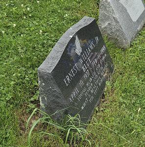 Weathered headstone with biological growth before professional grave care cleaning.